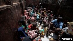 Sudanese people who fled the conflict in Geneina in Sudan's Darfur region, sit on a truck that will relocate them from a school where they were temporarily accommodated to a refugee camp in Adre, Chad, July 23, 2023.