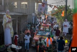 Large cutout portraits of Indian Prime Minister Narendra Modi are displayed along the route as Bharatiya Janata Party (BJP) candidate Tamilisai Soundararajan rides on top of a vehicle during a roadshow, Chennai, April 14, 2024.