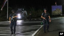 Kosovar police officers guard a road near the village of Banjska, northern Kosovo, Sept. 24, 2023.