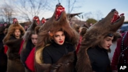 Members of a traditional bear pack take part in a parade before performing in a festival in Moinesti, northern Romania, Dec. 27, 2023. 