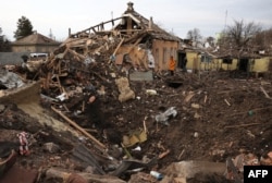 A local resident looks at a crater following a Russian missile attack in Chuhuyiv, Kharkiv region, Ukraine, on Feb. 15, 2024.