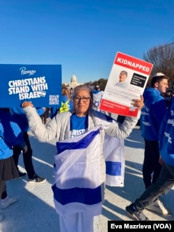 Seorang ibu menunjukkan poster dan foto anaknya yang disandera Hamas, dalam unjuk rasa untuk mendukung Israel di Washington DC, Selasa, 14 November 2023. (Foto: Eva Mazrieva/VOA)