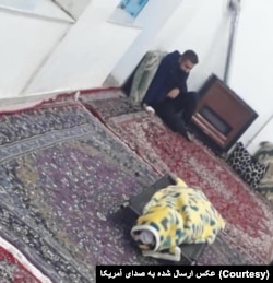 پیکر بی‌جان محمد حسن‌زاده که دوستش شهریار محمدی در کنار او نشسته است