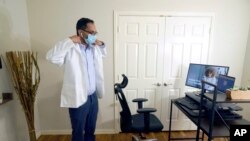 Dokter Vibin Roy bersiap untuk melakukan pemeriksaan virtual dengan pasiennya dari tempat kerjanya di rumahnya di Keller, Texas, pada 23 April 2021. (Foto:AP/LM Otero)