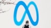 FILE - A person stands in front of a Meta sign outside the company's headquarters in Menlo Park, Calif., March 7, 2023. Facebook's decision to block news sharing on its platforms in Canada has cost small local news outlets a good chunk of their audiences.
