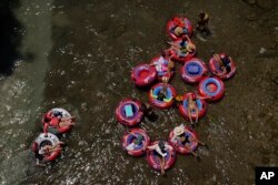 Tubers float the cool Comal River in New Braunfels, Texas, June 29, 2023.