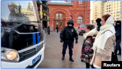 In this still frame taken from video, activists temporarily obstruct a police bus holding detained journalists from leaving the site where they were reporting on a group of women demanding the return of husbands who were mobilized to fight in Ukraine, in Moscow on Feb. 3, 2024.