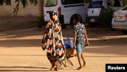People look for water during clashes between the paramilitary Rapid Support Forces and the army in Khartoum North, Sudan, April 20, 2023. 