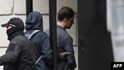 FILE - U.S. journalist Evan Gershkovich, right, is escorted outside the Lefortovsky Court in Moscow on Aug. 24, 2023.