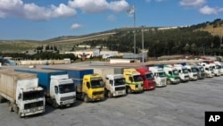 FILE - U.N. trucks with humanitarian aid for Syria following a devastating earthquake are parked at Bab al-Hawa border crossing with Turkey, in Syria's Idlib province, Feb. 10, 2023.