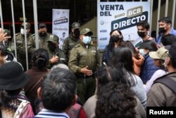 FILE - People stand outside Bolivia's Central Bank to buy U.S. dollars, in La Paz, Bolivia, March 7, 2023.