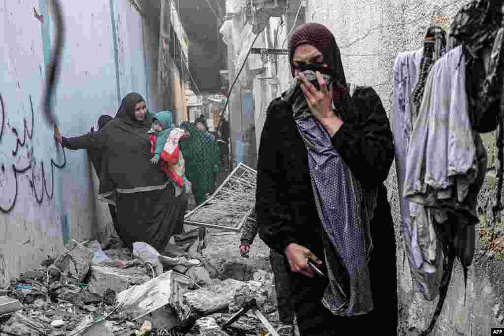 People find their way through a rubble-covered alley, following overnight Israeli bombardment in Rafah in the southern Gaza Strip, Feb. 25, 2024.