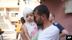 A Palestinian man says goodbye to his sick daughter before she was to leave the Gaza Strip to get treatment abroad through the Kerem Shalom crossing, in Khan Younis, Gaza Strip, June 27, 2024.