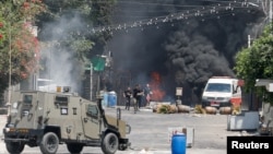 Palestinians run during clashes with Israeli forces amid an Israeli military operation in Jenin, in the Israeli-occupied West Bank, July 3, 2023.