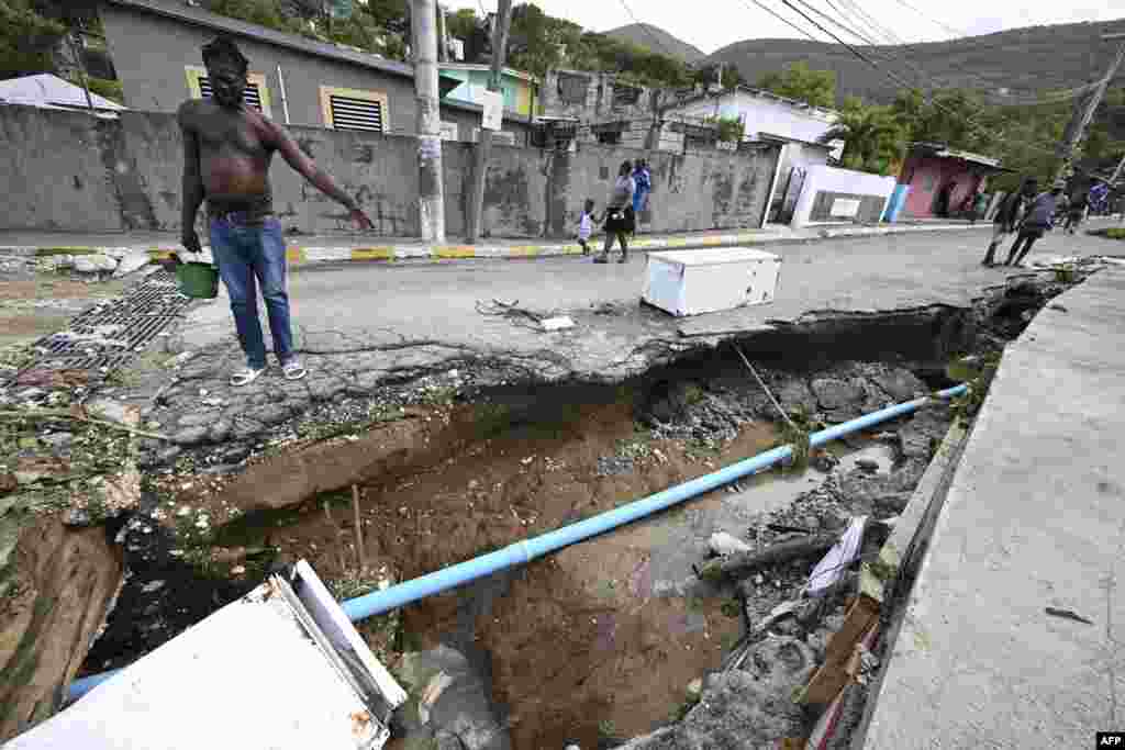 Residents look at a damaged drain in Shooters Hill, Jamaica, in the aftermath of Hurricane Beryl.&nbsp;Beryl powered towards Mexico and the Cayman Islands, threatening strong winds and a storm surge after battering Jamaica's southern coast.