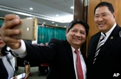 Pengacara Larry Gadon (kiri), berswafoto dengan Ketua Komite Kehakiman DPR, Reynaldo Umali, setelah sidang Komisi Keadilan DPR di metropolitan Manila, Filipina, Senin, 19 Maret 2018. (AP/Aaron Favila)