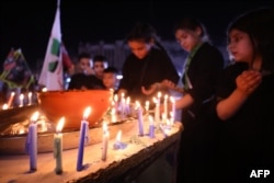 Iraqi Shiite Muslims light candles during a mourning ritual in al-Kifah district in Baghdad, July 27, 2023, in the lead-up to Ashura, a 10-day period commemorating the 7th-century killing of the Prophet Muhammad's grandson Imam Hussein.