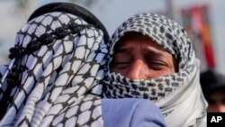 Relatives grieve during a funeral of a fighter with the Kataib Hezbollah who was killed in a US airstrike, in Baghdad, Iraq, Jan. 25, 2024.