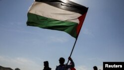 FILE — Houthi followers hold a Palestinian flag in solidarity with the Palestinians and to show support to Houthi strikes on ships in the Red Sea and the Gulf of Aden, in Sanaa, Yemen, Jan. 29, 2024. The U.S. reinstated sanctions on Yemen's Houthi rebels Friday.