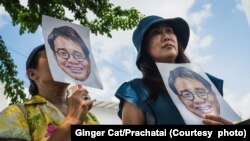 สิตานัน สัตย์ศักดิ์สิทธิ์ (ขวา) ถือภาพของวันเฉลิม สัตย์ศักดิ์สิทธิ์ น้องชายที่หายตัวไปขณะลี้ภัยที่กัมพูชา ขณะยืนแสดงออกเชิงสัญลักษณ์ เมื่ 21 กุมภาพันธ์ 2567