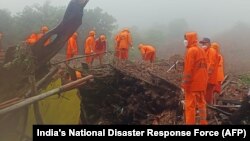 In this handout photograph released by India's National Disaster Response Force (NDRF) and taken on July 22, 2023, NDRF personnel search for victims at the site of a landslide at Irshalwadi village of Raigad district in Maharashtra state. 