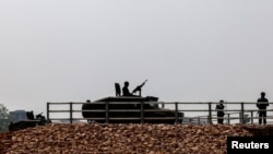 FILE - Military personnel stand guard as a stream of people queued at a border crossing to flee Myanmar, after the strategically-vital town of Myawaddy adjoining Thailand fell to anti-junta resistance, in Mae Sot, Tak province, Thailand, April 12, 2024.
