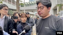 社民連內務副主席余煒彬接受傳媒訪問時，有便衣警察在後方近距離拍攝。(美國之音/湯惠芸)