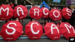 Activists with painted parasols parade on a street during a protest in Quezon City, Philippines, July 24, 2023, ahead of the second State of the Nation Address of Philippine President Ferdinand Marcos Jr.