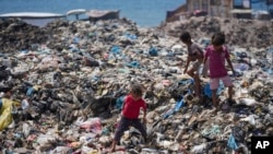 Palestinian children sort through trash at a landfill in Nuseirat refugee camp, Gaza Strip, June 20, 2024. 