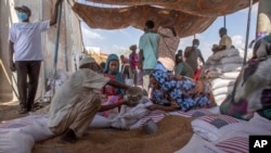 FILE - Pengungsi Tigray mengumpulkan jatah makanan dari USAID di Pusat Transisi Hamdeyat dekat perbatasan Sudan-Ethiopia, Sudan timur, Rabu, 24 Maret 2021. (Nariman El-Mofty/AP)