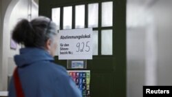 A woman enters a polling station during the 'Berlin 2030 Climate Neutral' referendum in Berlin, Germany, March 26, 2023. 