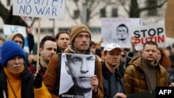 A man holds a photo of Alexey Navalny at a rally on Feb. 18, 2024, in front of the Russian embassy in Berlin, Germany, following news of the death of the Kremlin's most prominent critic in an Arctic prison. 