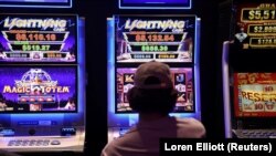 Seseorang sedang melakukan judi di mesin poker di sebuah pub di Sydney, Australia, 19 September 2022. (Foto: REUTERS/Loren Elliott)