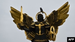 A crow sits on a sculpture of Kyiv's protector Archangel Michael on Independence Square on Nov. 1, 2023. 