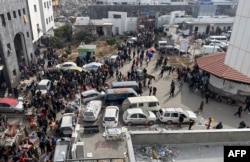 FILE - Displaced Palestinians gather in the yard of Gaza's Al-Shifa hospital, Dec. 10, 2023.