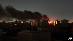 FILE - Smoke rises over the horizon as a fire burns after a strike in Khartoum, Sudan, April 16, 2023.