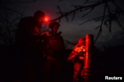 Ukrainian servicemen prepare to fire a mortar, as Russia's attack on Ukraine continues near the city of Bakhmut, Donetsk region, Ukraine, April 6, 2023.