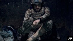 A Ukrainian soldier who lost his leg in a battle with the Russian troops and came back to the front with a prosthetic leg, sits in a trench in the Zaporizhzhia region, Ukraine, July 1, 2023.