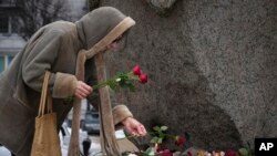 A woman pays tribute to Alexey Navalny at the monument where the first camp of the Gulag political prison system was established in St. Petersburg, Russia, Feb. 21, 2024. Navalny, the most famous Russian opposition leader, died in prison Feb. 16, at 47.
