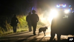 Lapolis eta Maine mache ak yon chyen nan zon yon pwopriyete nan vil Bowdoin, Maine, 26 Oktob, 2023. 