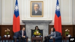 In this photo released by the Taiwan Presidential Office, Taiwan's President Tsai Ing-wen, right, talks to US Rep. Mike Gallagher on the Chinese Communist Party, left, in Taipei, Taiwan, Feb. 22, 2024. 
