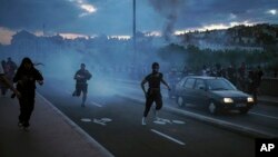 People run away during clashes with police in the center of Lyon, central France, June 30, 2023.