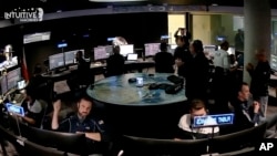 An image taken from video released by Intuitive Machines shows flight controllers at the Houston company reacting after its private spacecraft touched down on the moon, Feb. 22, 2024.