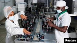 Rosalid Rwaru, Bio Foods Products Head of Sustainability, sorts yoghurt packed in plastic bottles on a conveyor belt at the Bio Food Products, in Nairobi, Kenya, Nov. 16, 2023.