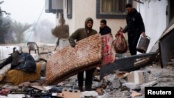 Palestinski civili iznose stvari iz kuće koja je pogođena u napadu izraelske vojske u Rafi (Foto: REUTERS/Ibraheem Abu Mustafa)