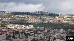 A picture taken in the village of Turmus Ayya near Ramallah city shows the nearby Israeli Shilo settlement in the background, in the occupied West Bank on Feb. 18, 2024. 