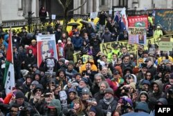 Supporters of WikiLeaks founder Julian Assange listen as his wife Stella Assange (unseen) makes a speech outside The Royal Courts of Justice, Britain's High Court, in central London, Feb. 21, 2024,