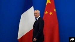 French Finance Minister Bruno Le Maire walks past the French and Chinese flags at the 9th China-France High Level Economic and Financial Dialogue held at the Diaoyutai State Guest House in Beijing, July 29, 2023. 