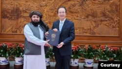 In this photo provided by the Taliban, newly appointed Taliban ambassador Assadullah Bilal Karimi is reportedly presenting his credentials to Hong Lei, director-general of the protocol department at China's Foreign Ministry, in Beijing on Dec. 1, 2023.