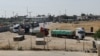 Trucks carrying aid wait to exit, on the Palestinian side of the border with Egypt, as the conflict between Israel and Palestinian Islamist group Hamas continues, in Rafah in the southern Gaza Strip, Oct. 21, 2023.